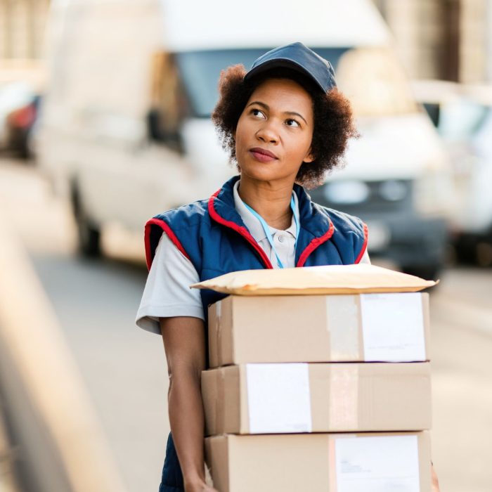 black-female-courier-carrying-packages-while-makin-2024-12-13-19-37-43-utc.jpg